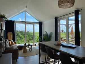 ein Esszimmer mit einem Tisch und einem großen Fenster in der Unterkunft Buitengoed de Boomgaard Utrecht - Bunnik in Bunnik