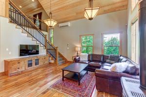 a living room with a leather couch and a tv at Elk Meadows Escape in Cle Elum