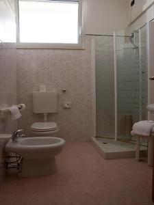 ein Bad mit einem WC und einer Glasdusche in der Unterkunft Hotel Monica in Chianciano Terme