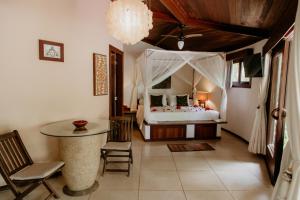a bedroom with a bed and a table and chairs at Paua Hotel Boutique in Pipa