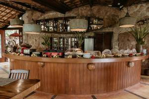 a bar in a restaurant with a stone wall at Paua Hotel Boutique in Pipa