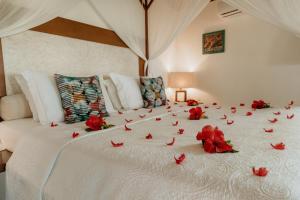 a bed with red rose petals on it at Paua Hotel Boutique in Pipa