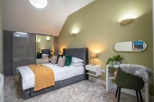 a bedroom with a bed and a chair and a mirror at All Saints House in Worcester