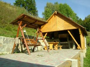 drewniany pawilon z dachem na patio w obiekcie Садиба Віват w mieście Orawczyk