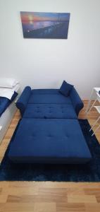a blue couch sitting in a living room at Casa Rusu - Govandari -Self check in-24h in Reşiţa