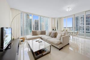 sala de estar con sofá blanco y ventana grande en ICON Brickell residences, en Miami