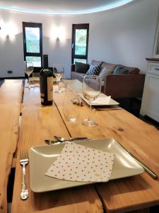 una mesa de madera con un plato y copas de vino en Hochwertige Wohnung mit Parkplatz im schönen Schwarzwald, en Altensteig