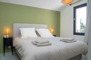 a bedroom with a large white bed with towels on it at Gîte de Merins, domaine de charme, face à la rivière, à 4km de la plage in Fleury