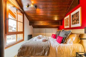 Un dormitorio con una cama con una pared roja. en Penthouse-Chalet in Arc 1950 SKI IN-SKI OUT, en Arc 1950 16 fotos más