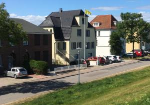 a street with houses and cars parked on the street at Hotel Sonnenschein - Spielerei im Sonnenschein in Dahme
