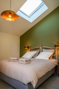 a bedroom with a large bed with a skylight at Domaine de Mérins, 10 couchages avec piscine, face à la rivière, à 4km de la plage in Fleury