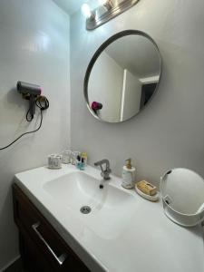 y baño con lavabo blanco y espejo. en MIAMI APARTMENT RENTAL, en Miami Beach