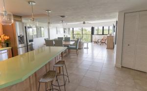 a kitchen and living room with a counter and chairs at SEA MIST - Oceanfront-Lake-Kayak-Paddleboard-Bike in Key Largo