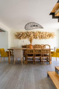 a dining room with a wooden table and chairs at Gîte de Merins, domaine de charme, face à la rivière, à 4km de la plage in Fleury