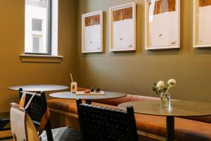 restauracja z dwoma stołami, krzesłami i oknami w obiekcie Sonder Ovation w Filadelfii