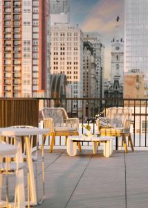 eine Gruppe von Tischen und Stühlen auf einem Balkon mit einer Stadt in der Unterkunft Sonder Ovation in Philadelphia