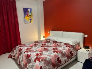 1 dormitorio con 1 cama con pared roja en CASA FLAN en Porto San Giorgio
