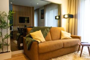 - un salon avec un canapé marron et des oreillers dans l'établissement The Beautiful Ones Studio, à Porto