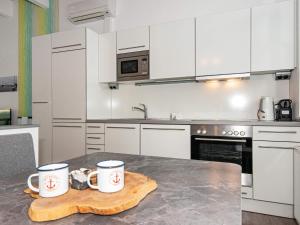 a kitchen with white cabinets and two mugs on a table at 4 person holiday home in Wendtorf in Wendtorf