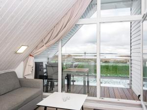 ein Wohnzimmer mit einem Sofa und einem großen Fenster in der Unterkunft 4 person holiday home in Wendtorf in Wendtorf