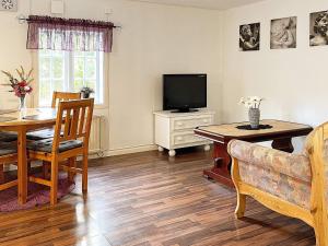 sala de estar con mesa y TV en Holiday home MÖNSTERÅS VII, en Mönsterås