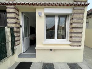 białe drzwi z oknem na boku domu w obiekcie Superbe T2 proche de Paris & Disneyland w mieście Ozoir-la-Ferrière