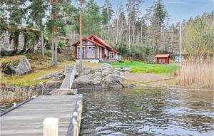 a house on the shore of a lake with a dock at Stunning Home In Arvika With Kitchen in Arvika