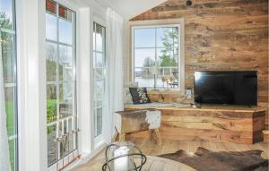 a living room with a television and a desk with a chair at Stunning Home In Arvika With 1 Bedrooms in Arvika