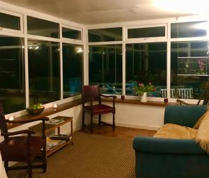 a living room with a table and chairs and windows at Leazes Cottage in Rothbury +4 photos