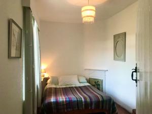 a bedroom with a bed with a striped blanket at Leazes Cottage in Rothbury