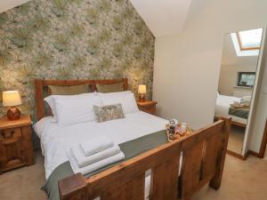 um quarto com uma cama grande e toalhas em The Coach House em Cheltenham