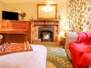 a living room with a chess board and a fireplace at Oakhurst in Newton Abbot