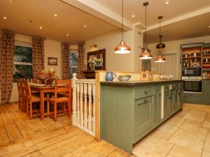 a kitchen with green cabinets and a dining room at Oakhurst in Newton Abbot