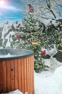 梅希莱尼采Domek w górach - Prywatne Jacuzzi, Sauna, Grota Solna - PANORAMA CHEŁM SKI&SPA的浴缸旁的雪花树