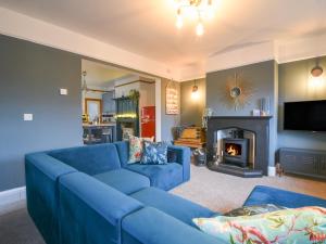 a living room with a blue couch and a fireplace at Waverley in Lyme Regis