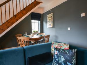 a living room with a blue couch and a table at Waverley in Lyme Regis