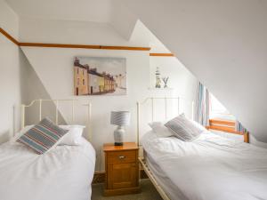 Un dormitorio con dos camas y una ventana en Waverley, en Lyme Regis