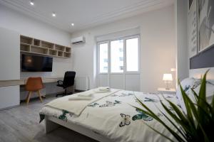 - une chambre blanche avec un lit et un bureau dans l'établissement Modern Apartment in the Heart of Bucharest, à Bucarest