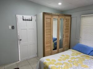 a bedroom with a bed and a closet and a door at Beverley Manor DIAMOND VALE' 2 Bedroom 1 Bath Apartment in Diego Martin