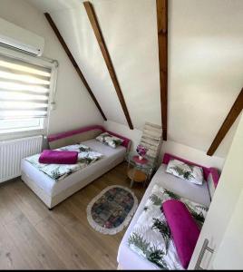 a attic room with two beds and a table at Vila Dolina Izvora in Sarajevo +32 photos