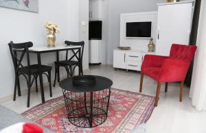 a living room with a red chair and a table at Ditto Flats in Istanbul