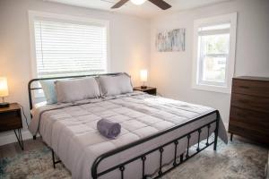 a bedroom with a large bed with two windows at Patio I Firepit I 65 TV w/ Netflix I 472mbps I WD in Vero Beach