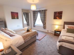 a bedroom with a bed and a large window at Olive Tree Cottage in Louth