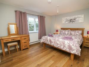 a bedroom with a bed and a desk and a mirror at Pen Y Banc in Builth Wells