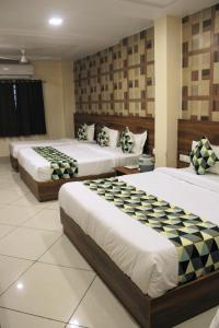 a hotel room with three beds in a room at Maruti Group of Hotels - Shri Naman in Nāthdwāra