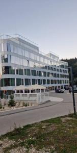 duży budynek z parkingiem przed nim w obiekcie Biala Perla Sunny Mountain 602 w mieście Sienna