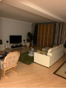 a living room with a white couch and a tv at Fairytale in Sony Center Berlin in Berlin