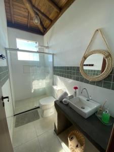 y baño con lavabo, aseo y espejo. en Taipu de Fora - Villa Ohana Flats en Taipu