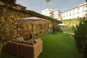 un patio con 2 sillas y una sombrilla en Aurora Garden Lodging - Rooms & Apartment, en Florencia