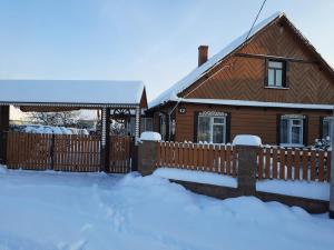 a house with a fence in the snow at Stajnia Bukwica konie i sauna in Narewka